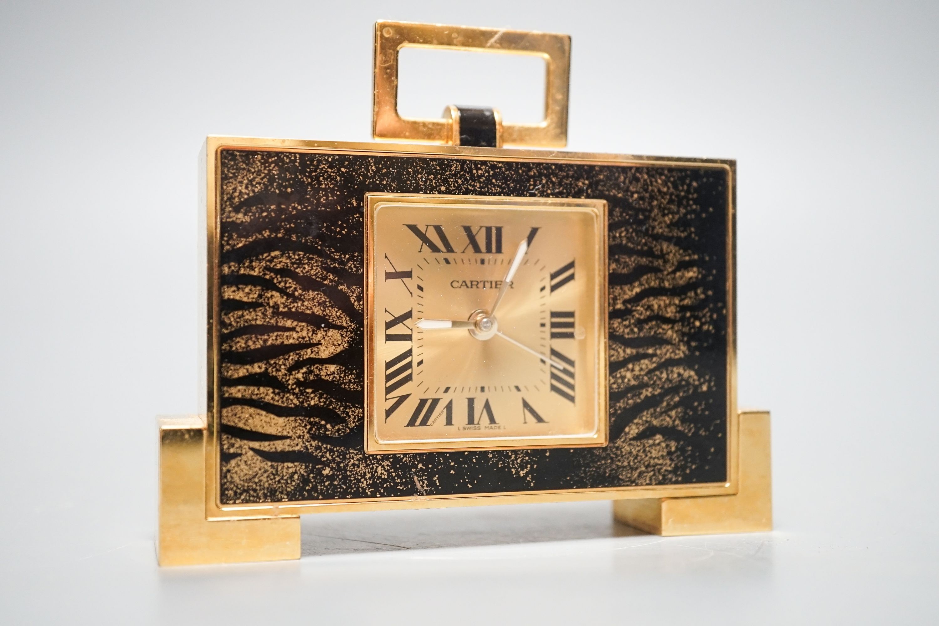 A cased Cartier gilt metal travelling clock, 10.5 cm wide, with certificate booklet
